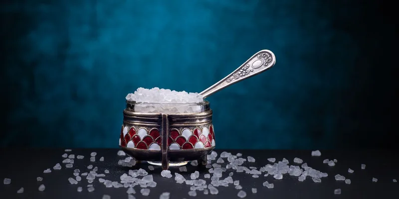 Close-up of a vintage sugar bowl with spoon on dark background
